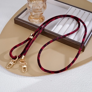 Macro shot of plush leopard print crossbody strap with high-gloss gold metal buckles