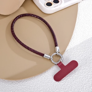 Détail de la lanière en cuir tressé bordeaux avec boucle à ressort en métal argenté et patch