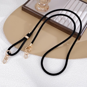 Detail of black woven crossbody phone strap with adjustable gold slider and metal clasps