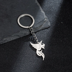 Detail shot of the polished stainless steel bird pendant on a stone background