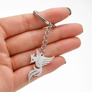 Detailed view of silver bird charm keychain with elegant phoenix cutout design