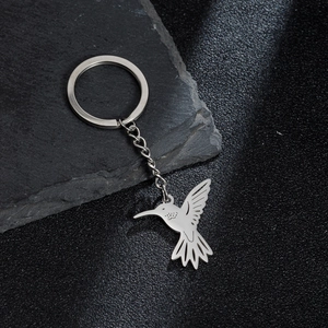 Detailed close-up of a silver stainless steel hummingbird keychain with hollow wing patterns