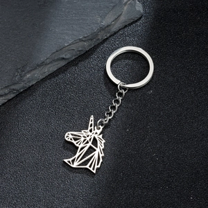 Detailed view of silver stainless steel origami unicorn keychain on a dark stone base