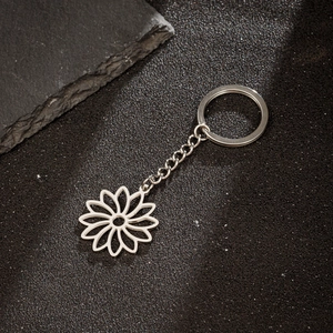 Silver stainless steel keychain with a delicate hollow sunflower charm on a black background