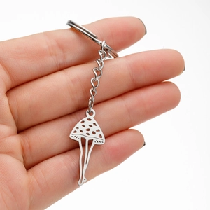 Porte-clés pendentif champignon minimaliste en acier inoxydable tenu à la main