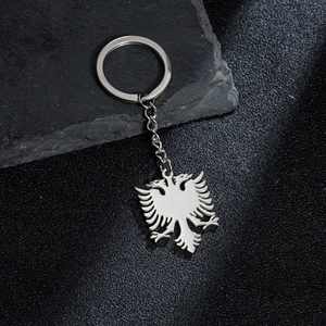 Silver stainless steel Albania double-headed eagle keychain on dark rock background