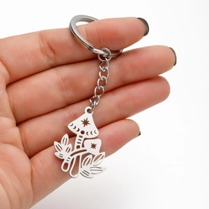 Minimalist stainless steel keychain with mushroom and star pendant held in hand