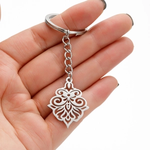 Detailed close-up of a mandala flower pendant keychain held in hand for scale