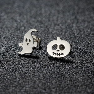 Detail van asymmetrische Halloween oorbellen met spook en pompoen op een zwarte kaart