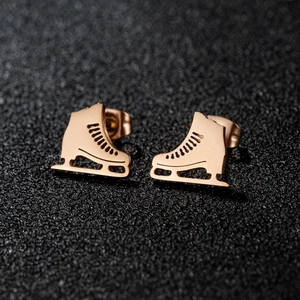 Vue macro des boucles d'oreilles patins à glace en or rose avec détails ajourés
