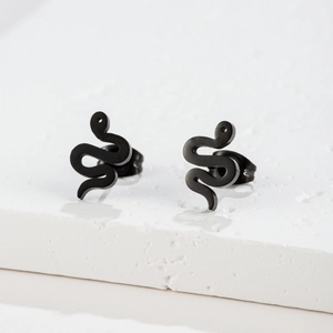 Macro shot of minimalist black snake studs on a textured stone display for clear detail
