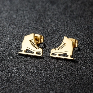 Boucles d'oreilles patins à glace dorées avec détails ajourés et reflets métalliques chics
