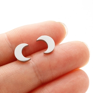 Gros plan détaillé d'une boucle d'oreille en croissant de lune montrant la taille réelle