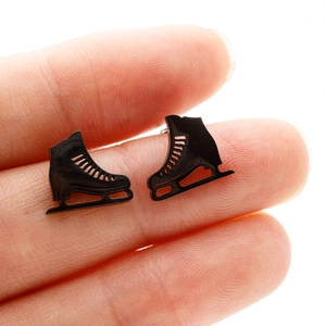 Gros plan détaillé de boucles d'oreilles patins à glace noirs montrant leur taille réelle