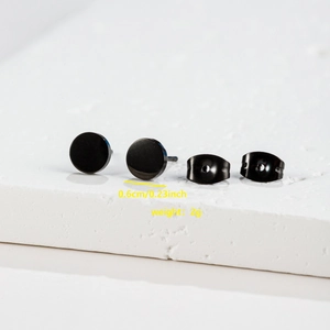 Macro detail of black polished stainless steel stud earrings showing 0.6cm diameter