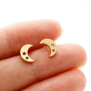 Minimalist gold moon and star stainless steel stud earrings shown on finger