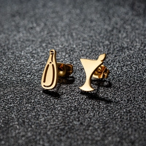 Asymmetric gold wine bottle and glass studs for women on dark glittery background