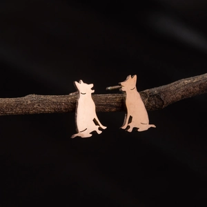 Minimalist dog silhouette stud earrings in rose gold finish on a natural branch