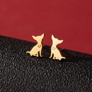 Pendientes minimalistas de Chihuahua dorados con detalle de corazón sobre fondo de cuero