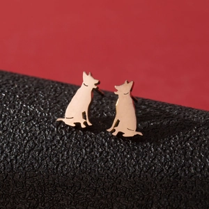 Detail of golden stainless steel hound dog silhouette earrings on a textured stand