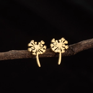 Minimalist golden dandelion flower stud earrings displayed on a dark wooden branch