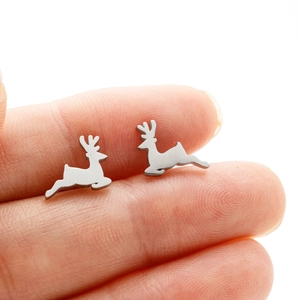 Macro shot of silver deer stud earrings on a fingertip showing the petite size