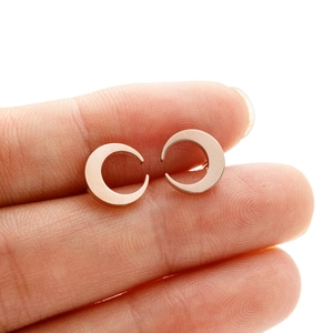 Detail shot of rose gold crescent moon earrings showing the petite size and polished finish