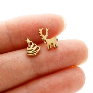 Macro shot of gold stainless steel asymmetric Christmas tree and deer stud earrings