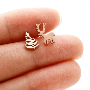 Close-up of asymmetric Christmas tree and elk stud earrings in polished rose gold finish
