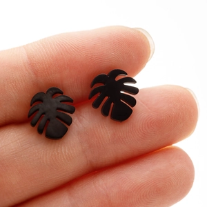 Detailed view of black monstera leaf stud earrings with a matte textured finish