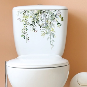 Detail showing tropical watercolor green leaves and white flowers on a white toilet tank