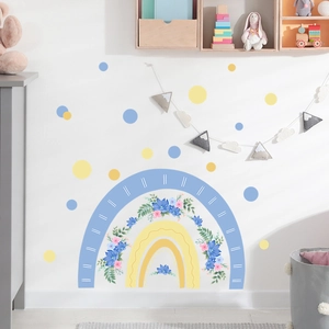 Detail view of cartoon rainbow wall sticker with floral accents in a cozy child bedroom