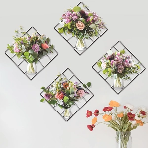 Set of four diamond-shaped black metal mesh wall hangings with glass vases and floral decor