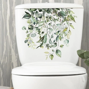Detail of self-adhesive watercolor tropical green leaves wall sticker on a white toilet lid