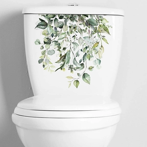 Close-up of watercolor tropical green leaves wall sticker on white ceramic toilet tank