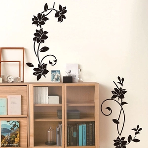 Dettaglio di eleganti adesivi murali neri a forma di fiori e viti su una parete di casa