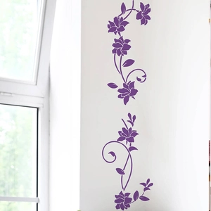 Dettaglio di eleganti adesivi murali con fiori viola applicati su una parete bianca della camera