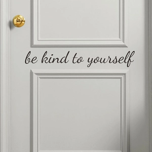 Minimalist 'be kind to yourself' wall decal on a modern grey wooden door