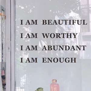 Inspirational mirror decals with motivational phrases on clear glass surface