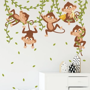 Cartoon monkey wall decals for nursery with vines and leaves on a clean white wall