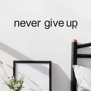 Inspirational 'Never Give Up' black vinyl wall decal displayed on a bedroom wall