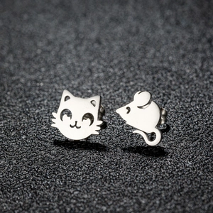 Macro shot of polished asymmetric cartoon cat and mouse stud earrings in silver metal