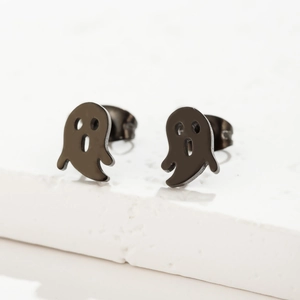Détail de boucles d'oreilles fantômes en acier noir sur fond de pierre blanche