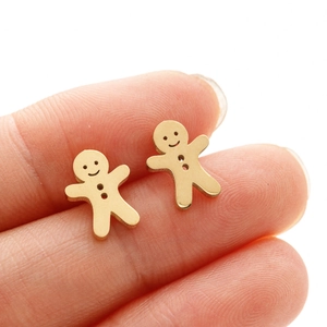 Macro shot of gold gingerbread man stud earrings with mirror-polished finish details