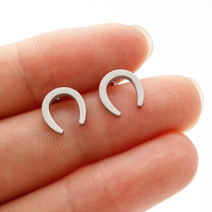 Gros plan de boucles d'oreilles fer à cheval en U avec texture métallique brossée