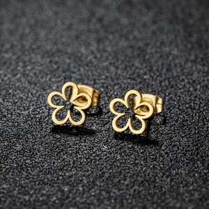 Macro shot of minimalist gold hollow flower stud earrings with a polished steel finish