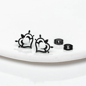 Macro de boucles d'oreilles cœur noir évidé avec fermoirs assortis sur céramique