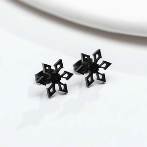 Detailopname van zwarte sneeuwvlok oorknopjes met een hol geometrisch metalen ontwerp