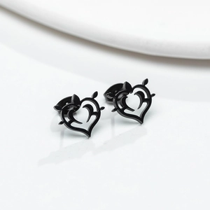 Détail de boucles d'oreilles cœur noir mat avec un design artistique ajouré en épines