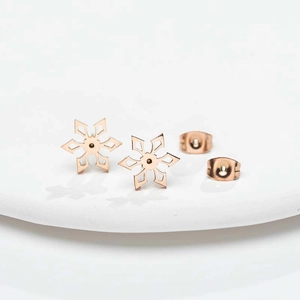 Gedetailleerde macro-opname van roségouden sneeuwvlok oorbellen met vlindersluiting